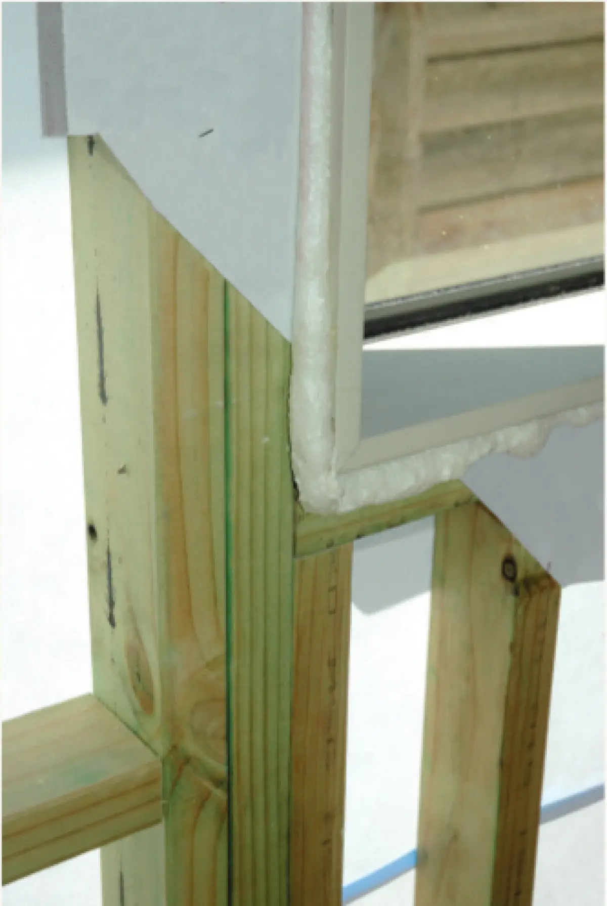 Close‑up photo showing a continuous air seal applied around a window opening before interior trimming is installed