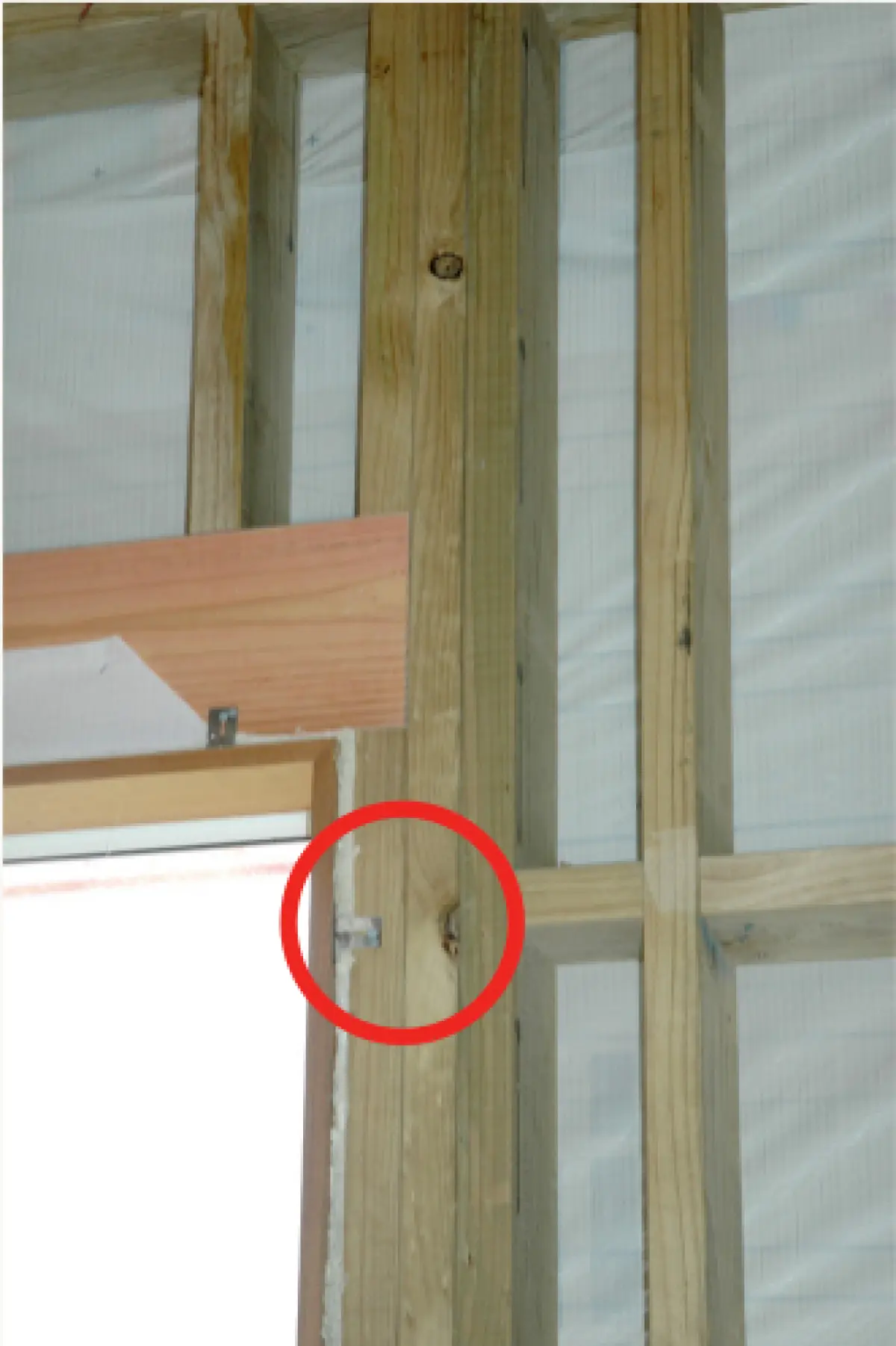 Photo showing a potential air gap beside a timber packer at a window frame within wall framingPhoto showing a potential air gap beside a timber packer at a window frame within wall framing
