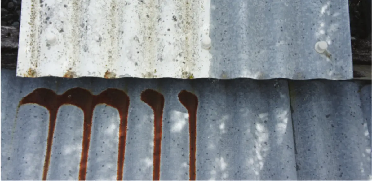 Photograph showing corrugated metal roofing with vertical rust stains running down the surface