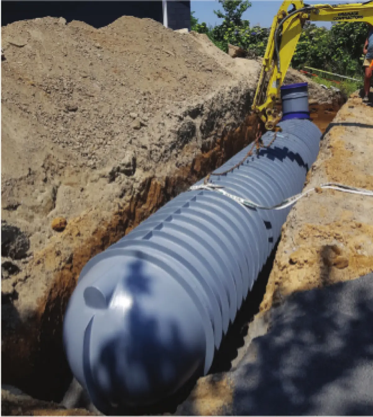 Photograph showing a large plastic tank installed in an excavated trench