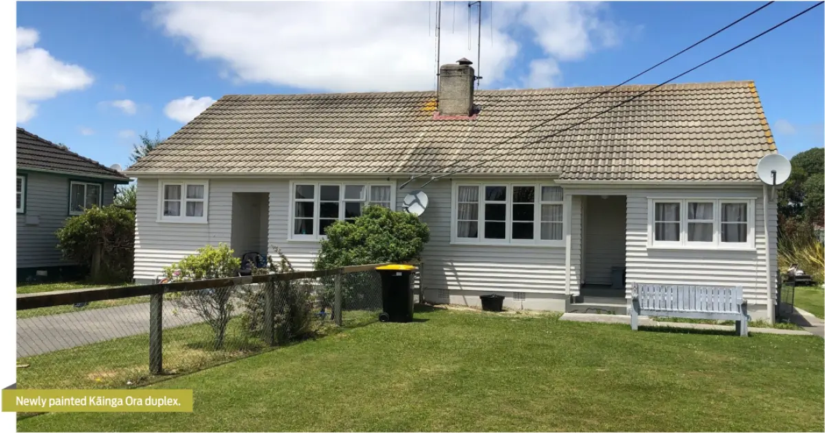 Photograph showing a single‑storey duplex house with a front lawn