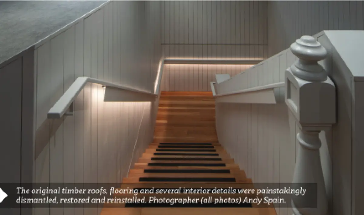 Photograph showing an interior staircase with timber steps, white painted walls, and handrails on both sides