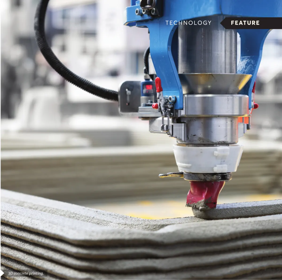 Photograph showing a robotic construction printer depositing layers of concrete to form a stepped structure