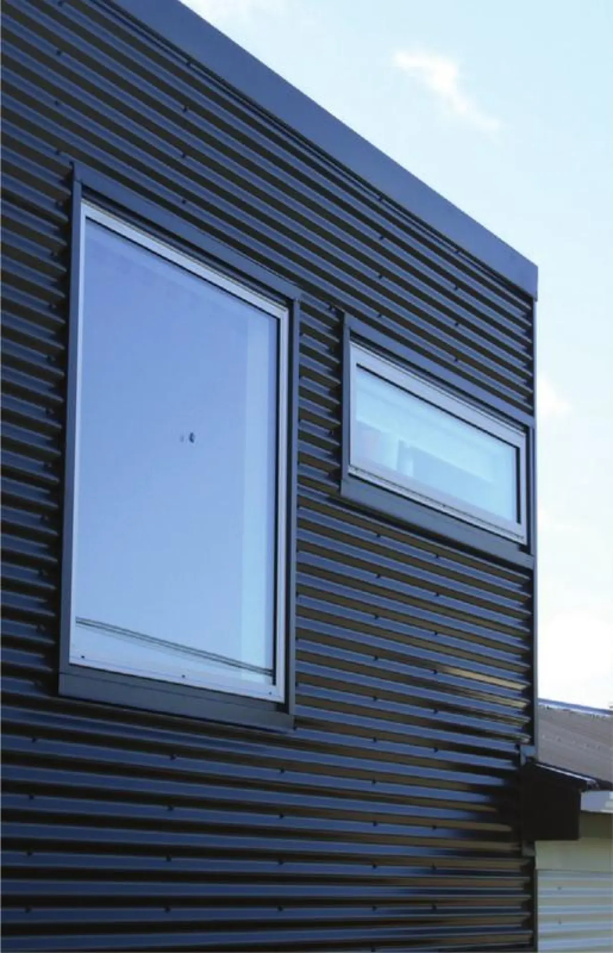 a photo of corrugated cladding painted black on the side of a building