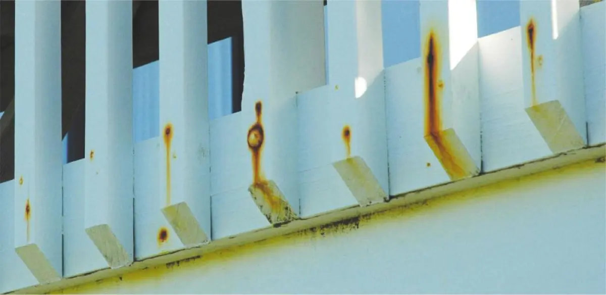 A photo of rust falling down a wooden fence