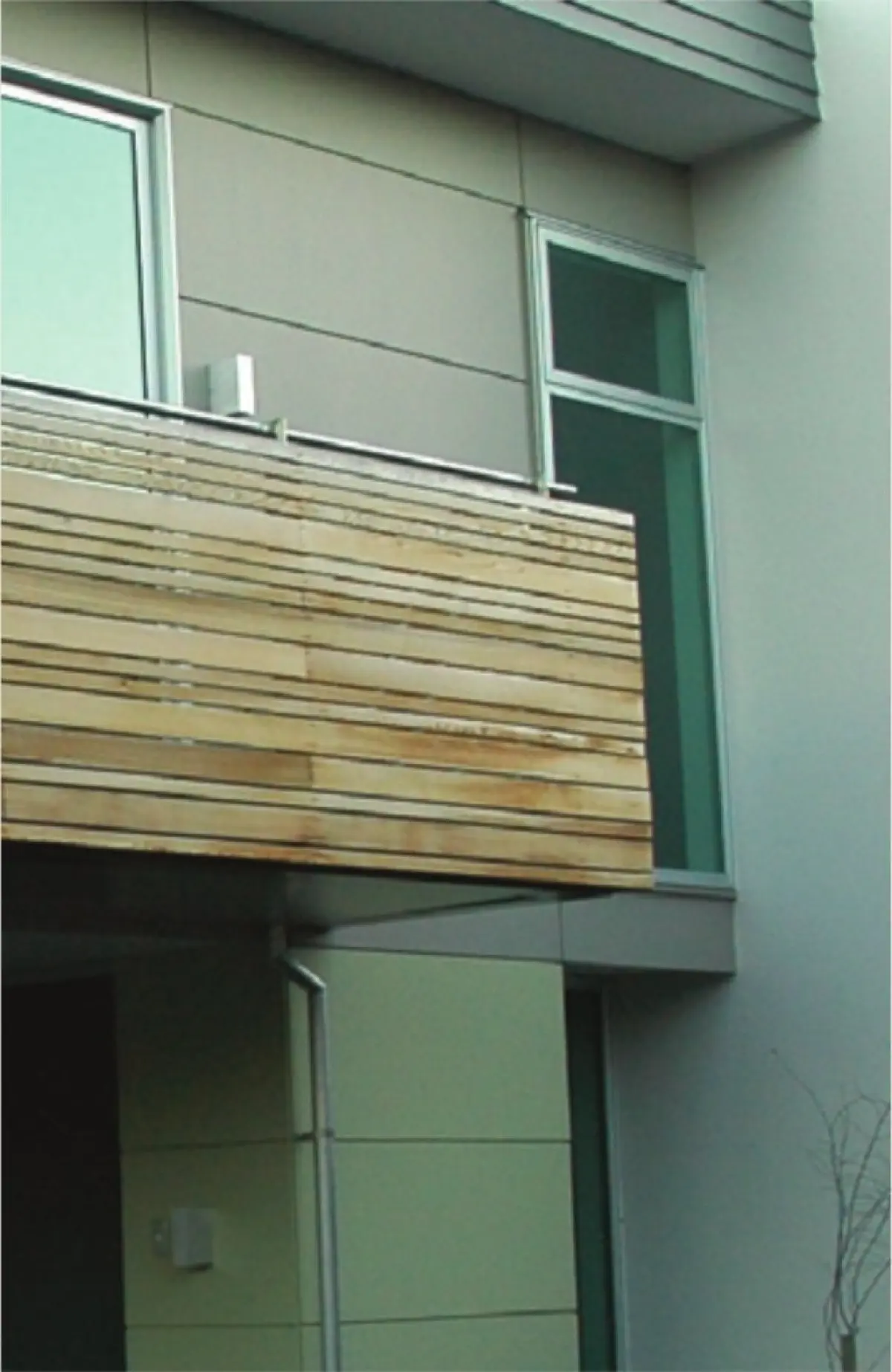 Photograph showing a building façade with a projecting balcony and timber railing