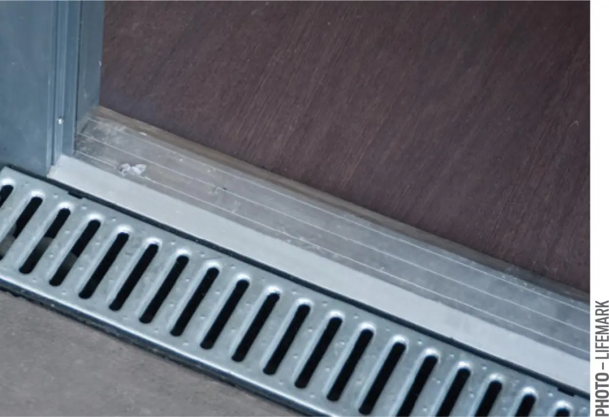 figure five a photo of a threshold drainage channel with a grating that is perpendicular to the door frame