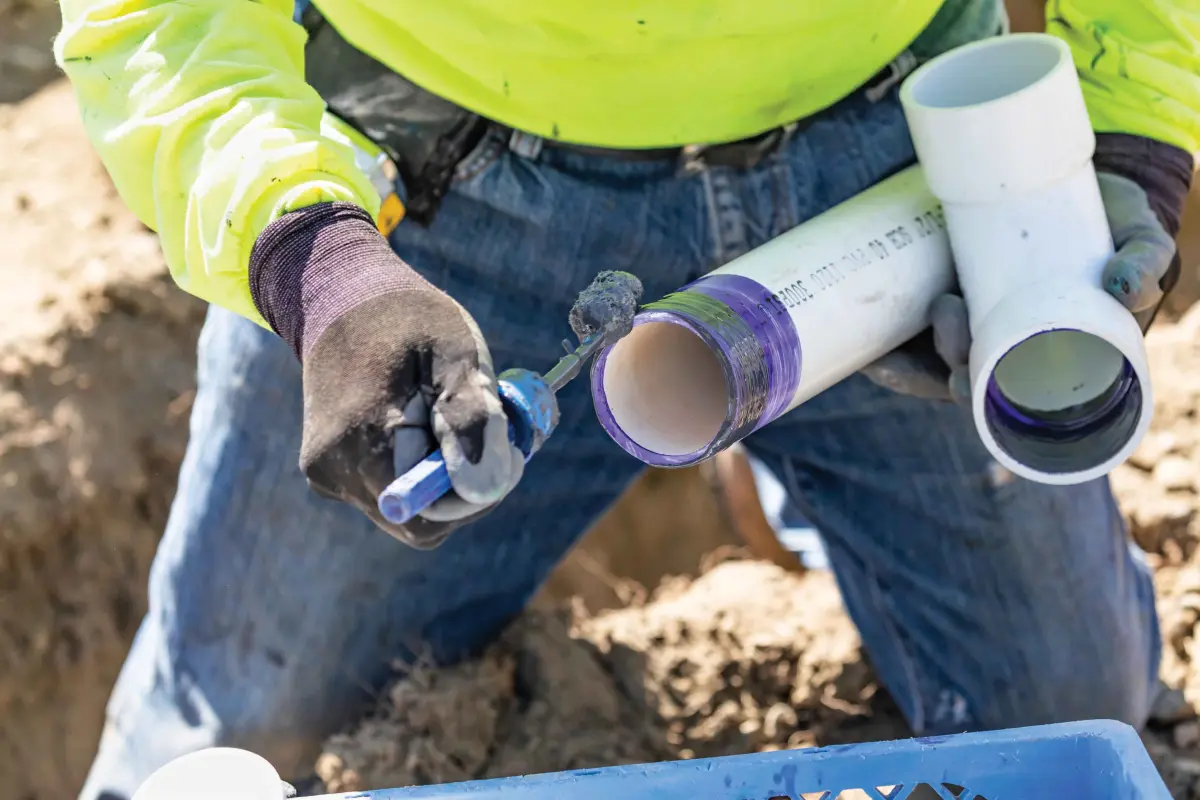 Plumber cutting plastic pipe
