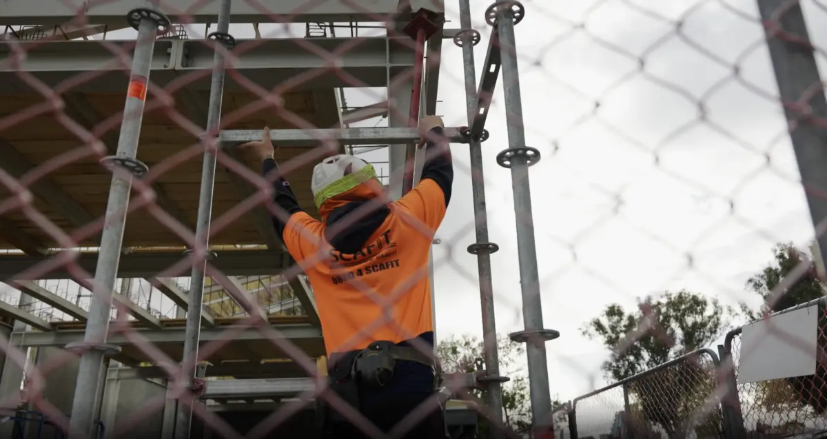 Person adjusting scaffolding on building site