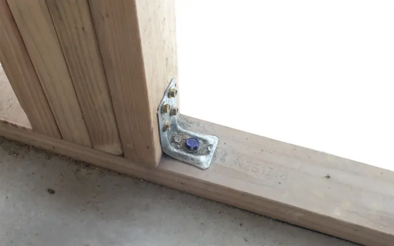 Braced wall bottom plate to concrete slab connections