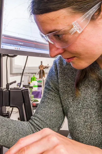 young female researcher using testing equipment in a materials testing lab