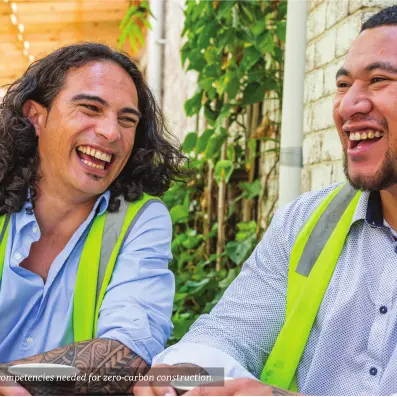 Photograph showing two people wearing high‑visibility vests laughing together