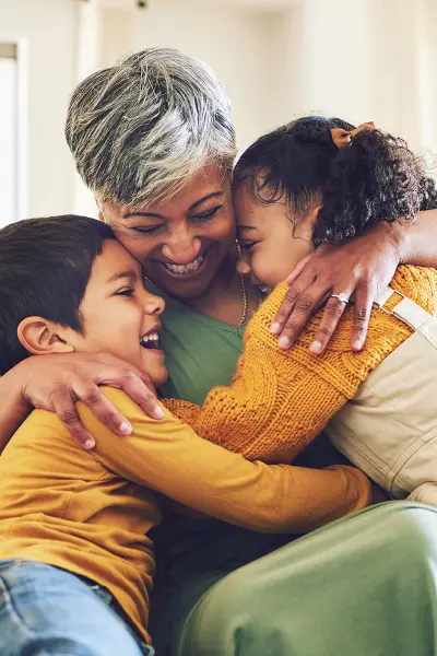 two young children hugging their grandma